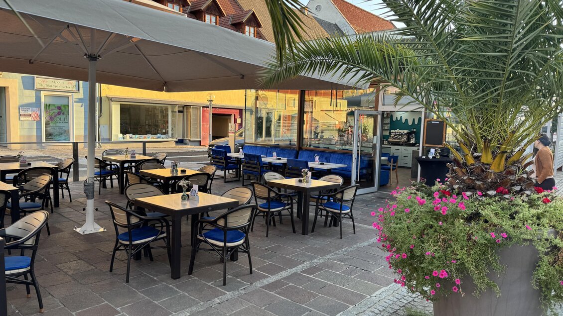 Ein gemütliches Restaurant im Freien mit gepflegten Tischen und Stühlen. Palmen und Blumen verleihen dem Bereich eine einladende Atmosphäre. | © Mesut Tunc, Stadtcafe
