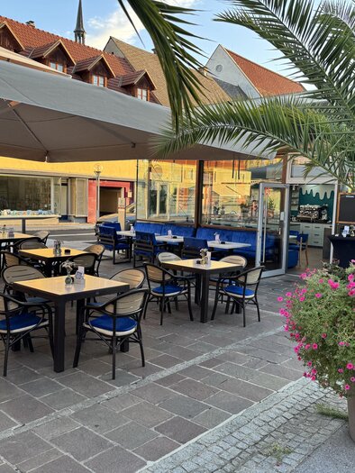 Ein gemütliches Restaurant im Freien mit gepflegten Tischen und Stühlen. Palmen und Blumen verleihen dem Bereich eine einladende Atmosphäre. | © Mesut Tunc, Stadtcafe