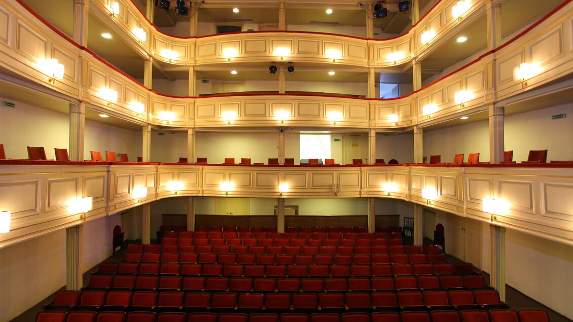 Ein stilvolles Theater mit rotem Sitzplatz und mehreren Ebenen. Die Beleuchtung schafft eine einladende Atmosphäre. | © TVB Erzberg-Leoben
