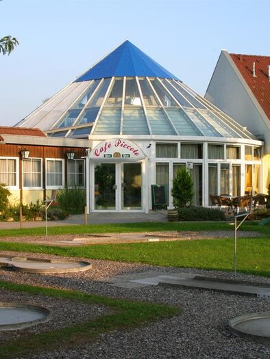 Eingangsbereich von Stefan's Gasthaus & Kegelbahn in Mooskirchen mit Minigolfanlage und Grünfläche. | © Franz Zweiger