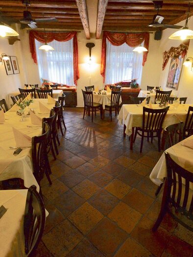 Ein gemütliches Restaurant mit Holzdecke und rustikalem Charme. Die Tische sind elegant gedeckt und laden zum Verweilen ein. | © Taj Mahal