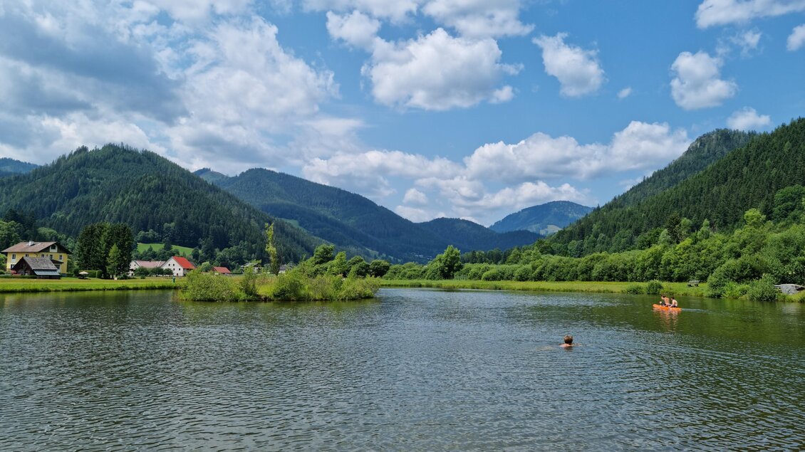 Badeteich mit kleiner Insel in der Mitte.