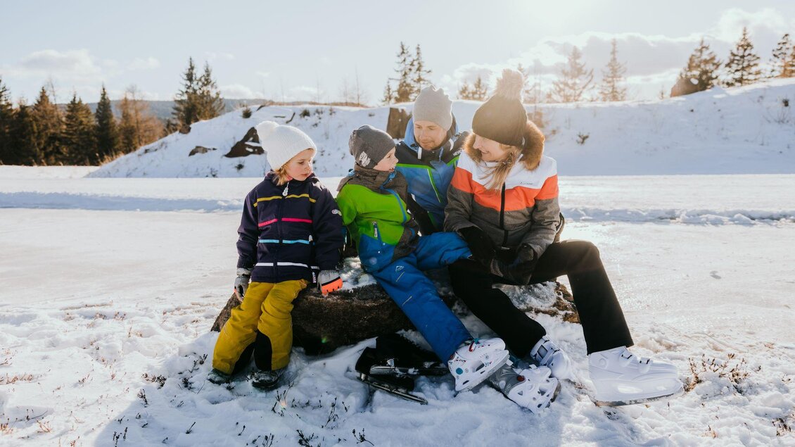 Eine Gruppe von Kindern sitzt im Schnee und genießt die Winterzeit. Sie tragen bunte Winterkleidung und wirken fröhlich. | © TV Südsteiermark - Lupi Spuma