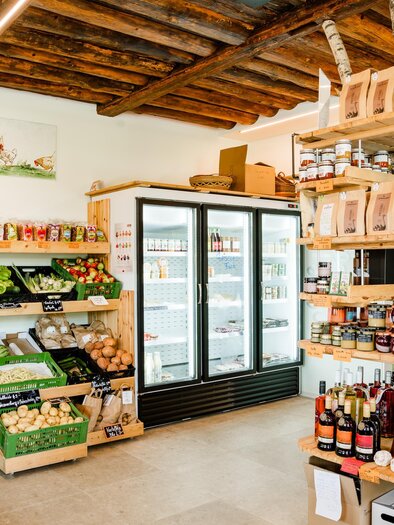 An inviting grocery store with fresh vegetables and fruits. Shelves are filled with various products, including beverages and canned goods. | © Region Graz - Mias Photoart