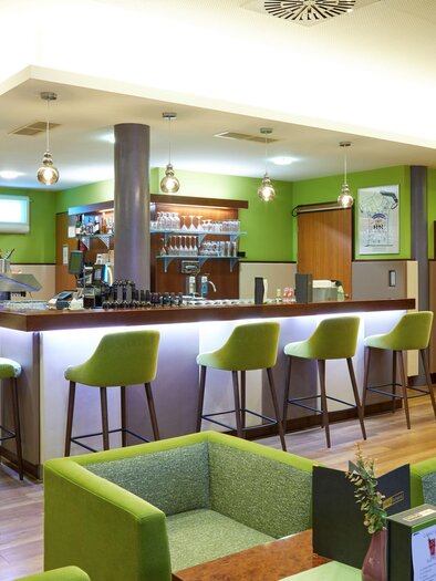 Eine moderne Bar mit hellen Farben und bequemen Sitzgelegenheiten. Die Theke ist gut bestückt und einladend gestaltet. | © Hotel Fontana