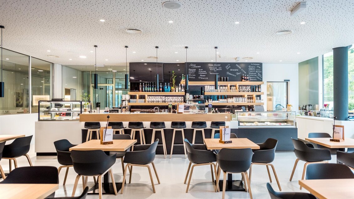 Cafébereich der Therme NOVA in Köflach mit Tischen, Stühlen, Bar und großen Fenstern im modernen Innenraum. | © Hotel & Therme NOVA