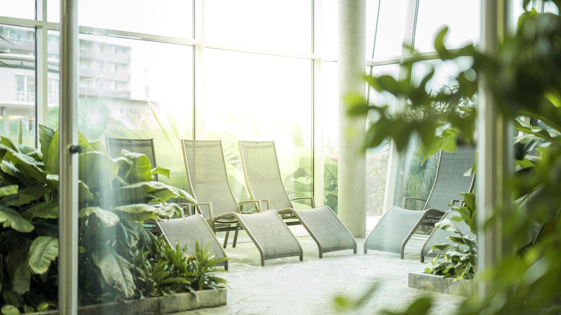 Tropenwald-Ruheraum der Therme NOVA in Köflach mit Liegen, üppigen Pflanzen und großen Fenstern im Innenbereich. | © Hotel & Therme NOVA