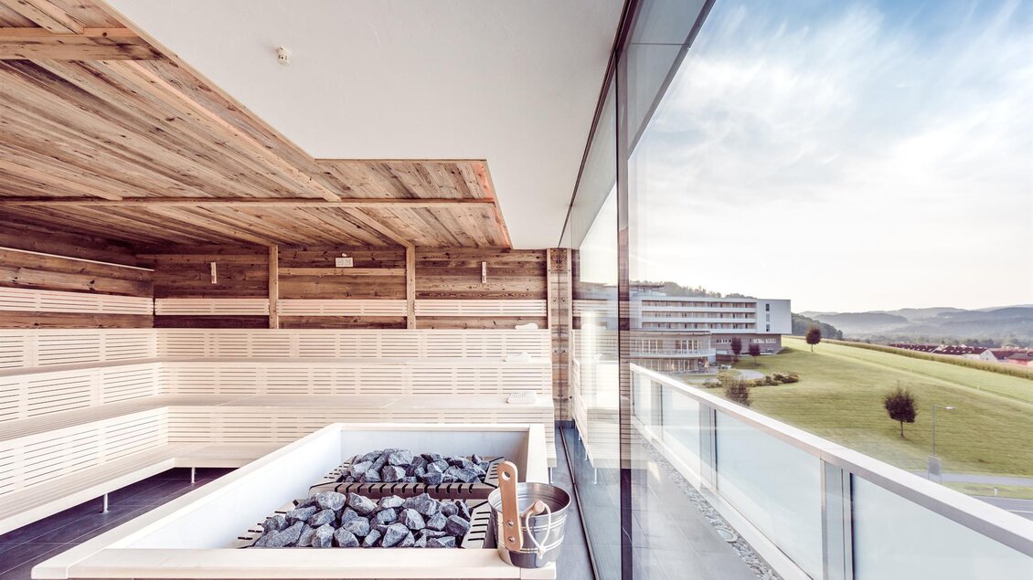 Saunabereich der Therme NOVA in Köflach mit Holzinterieur, Steinen und Panoramablick über die steirische Landschaft. | © Hotel & Therme NOVA