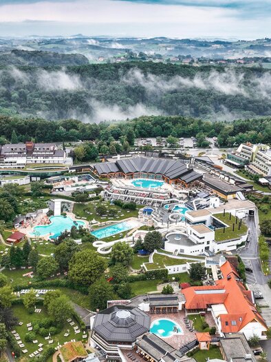 <p>Ein weitläufiges Resort mit mehreren Gebäuden und verschiedenen Schwimmbädern. Umgeben von grünen Wäldern und sanften Hügeln. Thermenresort Loipersdorf in Bad Loipersdorf.</p> | © TRL