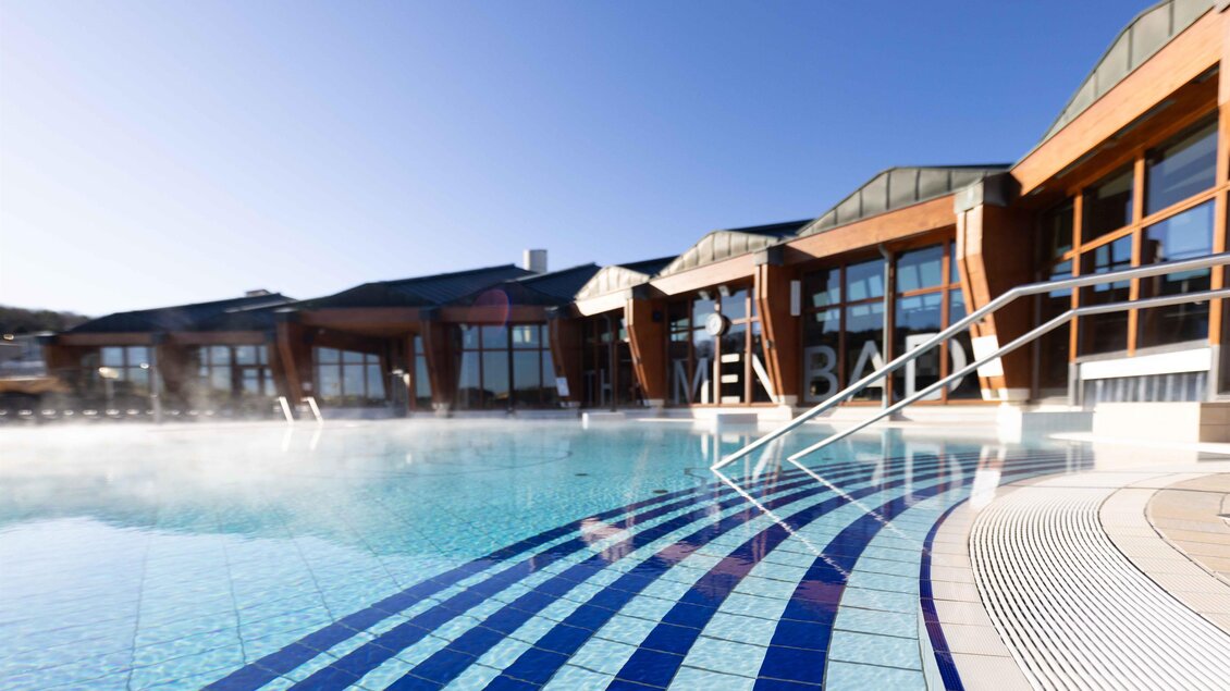 <p>Ein schöner Außenpool mit einer modernen Architektur im Hintergrund. Die Wasseroberfläche reflektiert den klaren Himmel und sorgt für eine entspannte Atmosphäre. Thermenresort Loipersdorf in Bad Loipersdorf.</p> | © TRL