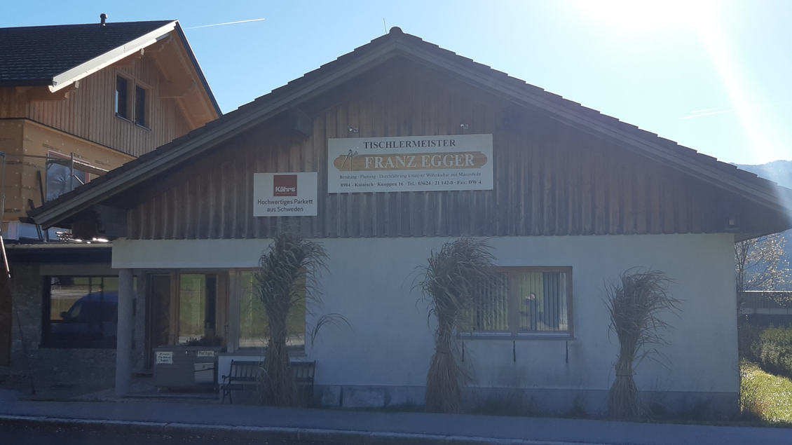 Ein Holzgebäude mit einem Schild der Tischlerei Franz Egger. Es gibt eine Bank und Pflanzen auf der Vorderseite. | © TVB Ausseerland Salzkammergut_Daniela Casari