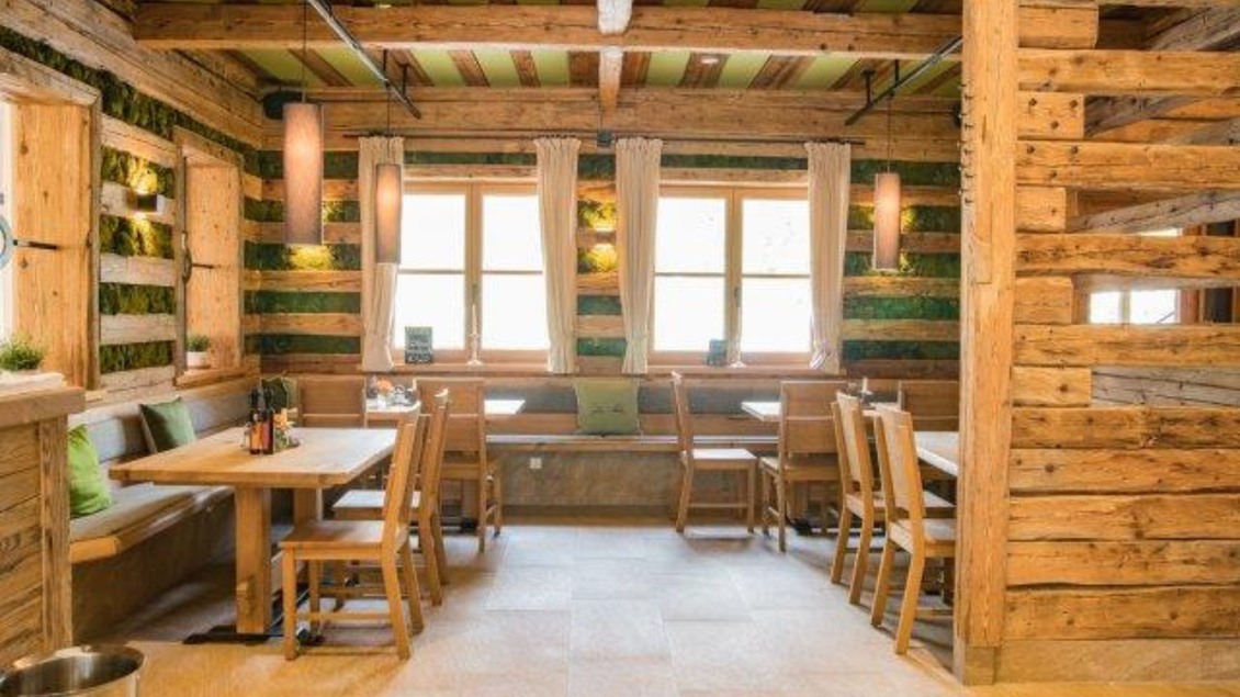 Ein gemütliches Restaurant mit Holzbau und grünen Akzenten. Die Einrichtung ist modern und einladend. | © Tischlerei Egger