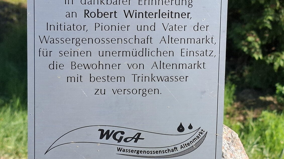 Ein Gedenkschild für Robert Winterleiter, den Initiator der Wassergenossenschaft Altenmarkt. Es würdigt seinen Einsatz für die Trinkwasserversorgung der Bewohner von Altenmarkt.