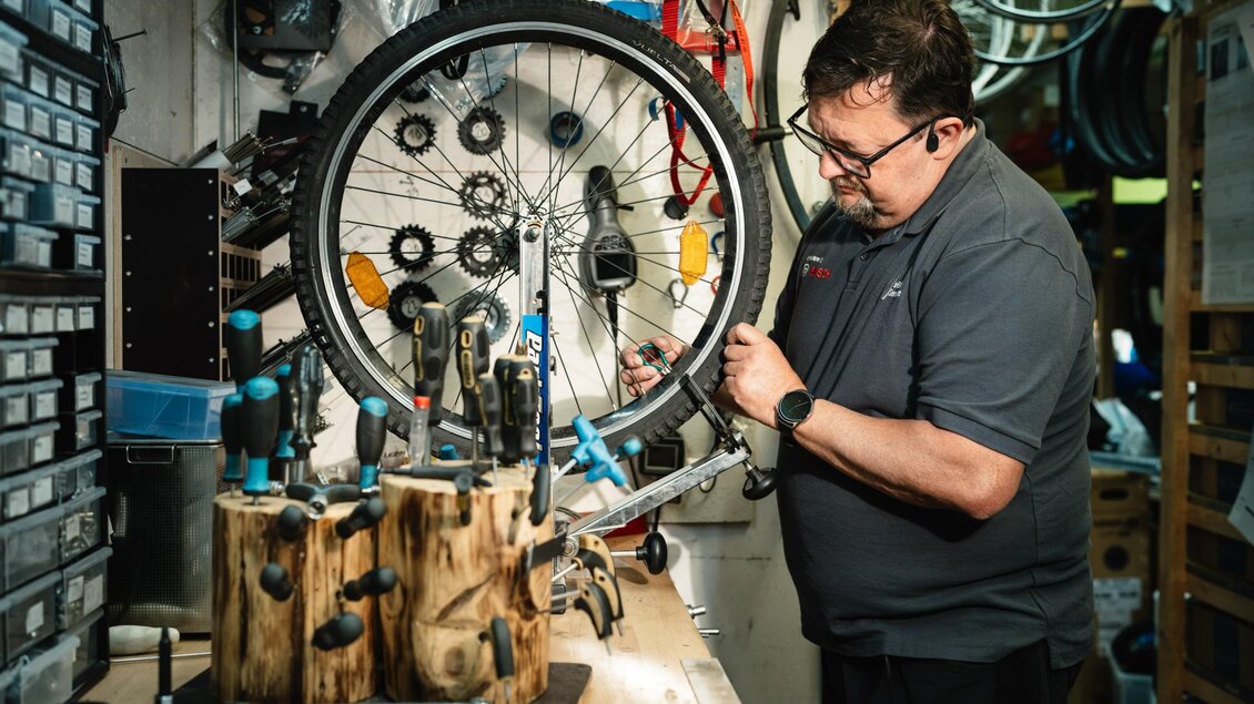 Herr Messner repariert einen Fahrradreifen in der Werkstatt von Trittmeister in Premstätten. | © Bernd Grosseck