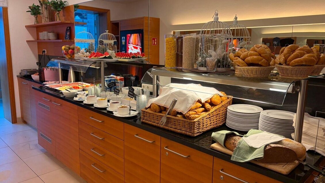 Ein Frühstücksbuffet mit frischen Croissants, Brötchen und einer Auswahl an Getränken. Der Tisch ist ordentlich gedeckt und es gibt frisches Obst in Körben. | ©  Villa Styria, Bad Aussee