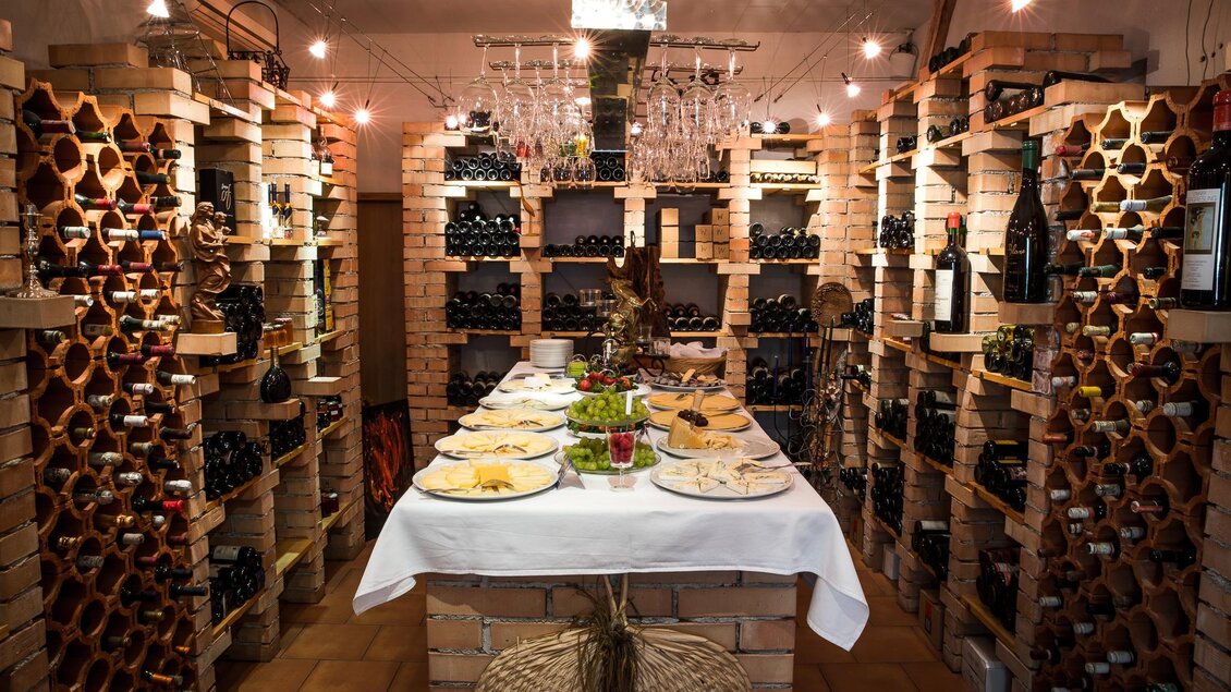 Gedeckter Verkostungstisch in der Vinothek Ellersdorfer in Köflach, umgeben von Weinregalen. | © Ellersdorfer