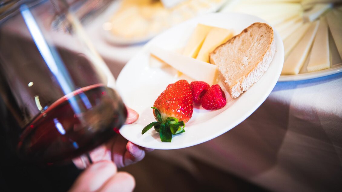 Glas Rotwein mit Käse, Brot und Beeren auf einem Verkostungsteller in der Vinothek Ellersdorfer in Köflach.  | © Ellersdorfer