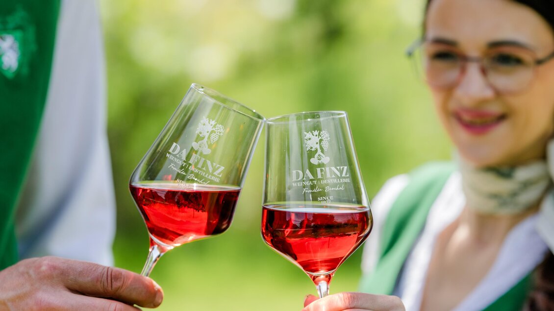 Zwei Personen stoßen mit Gläsern Schilcherwein im Weingut Destillerie Da Finz in Mooskirchen an. | © Region Graz - Mias Photoart
