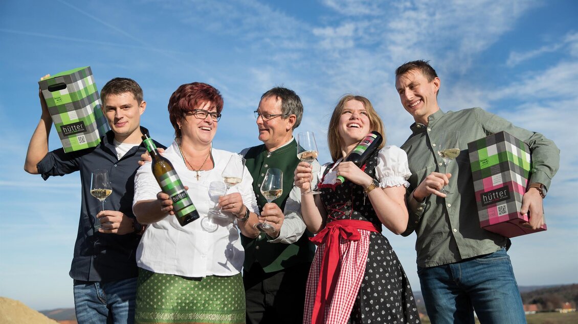 <p>Familie Hütter hält Getränke vom Weingut Hütter in St. Anna am Aigen in den Händen. Sie stehen im Freien bei sonnigem Wetter und lachen zusammen.</p> | © Stefan Hütter