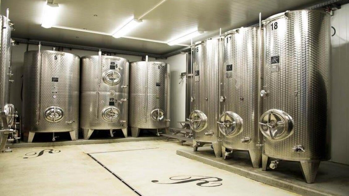 Ein Raum mit mehreren silbernen Fermentationsbehältern. Die Wände sind hell und die Beleuchtung ist gleichmäßig. | © Weingut Reinisch