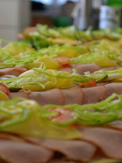 Ein Tisch mit einer Vielzahl von belegten Brötchen. Die Brötchen sind mit Schinken, Käse, Tomaten und grünen Paprika belegt. | © Fam. Paar