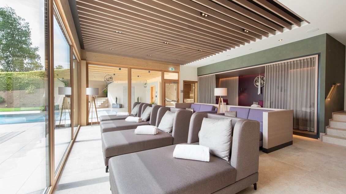Ein modernes Wohnzimmer mit gemütlichen Liegen und großen Fenstern. Der Raum hat einen eleganten und einladenden Stil. | © Helmut Schweighofer