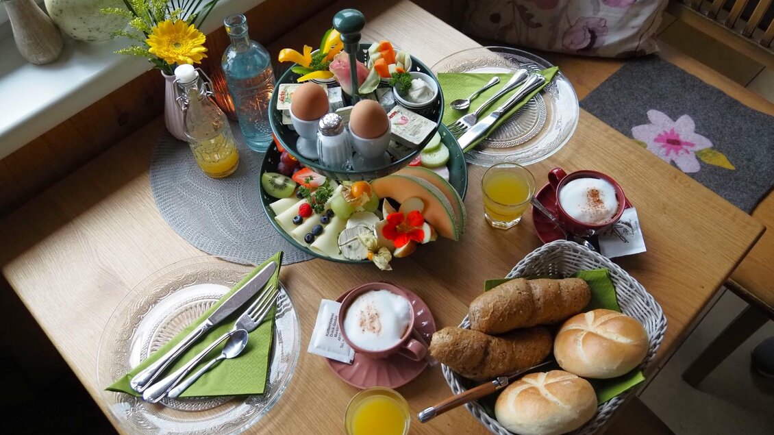 Ein gedeckter Tisch mit einem liebevollen Frühstück. Er beinhaltet frische Brötchen, Obst, Eier und Getränke. | © Tourismusverband Ausseerland