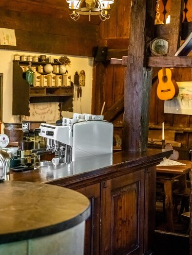 Ein gemütliches Restaurant mit Holzdekor und einer Theke. An der Wand hängen Instrumente und Bilder, die eine einladende Atmosphäre schaffen. | © Stephan Friesinger