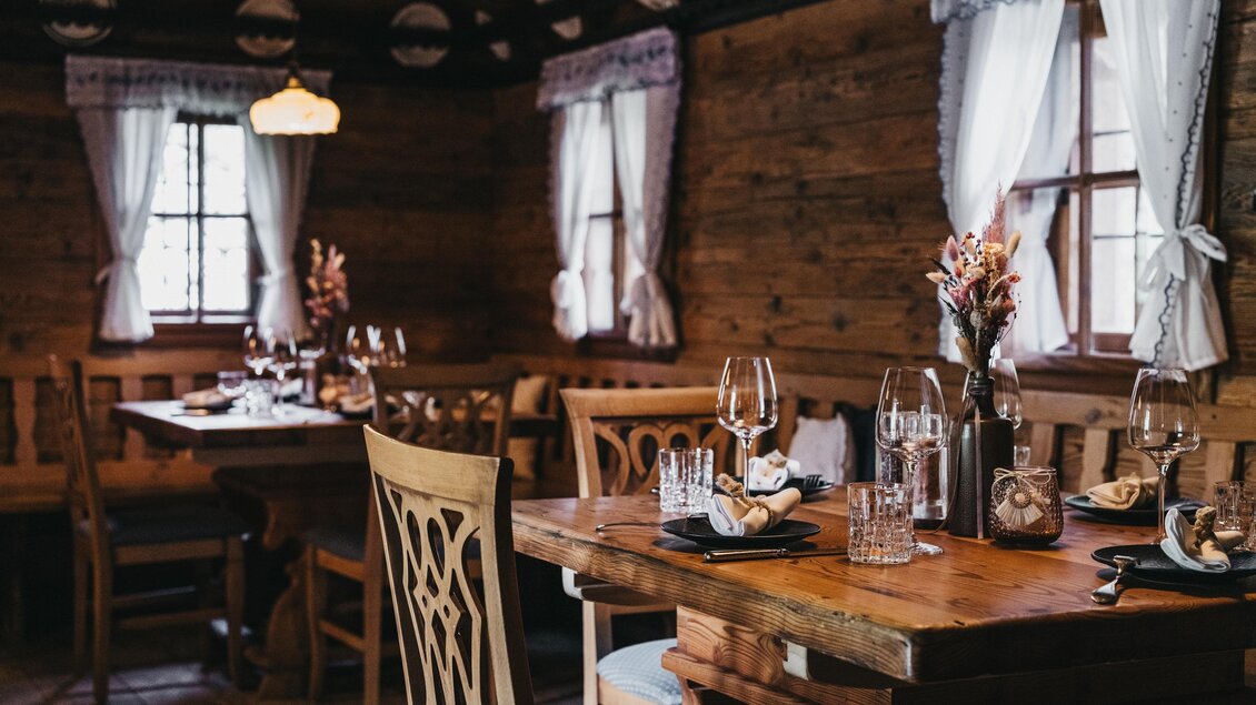 Ein gemütliches Restaurant mit Holzinterieur und warmem Licht. Die Tische sind elegant gedeckt und laden zum Verweilen ein. | © Heldentheater