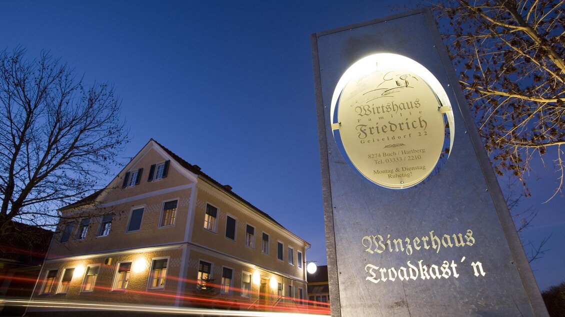 Ein gemütliches Weinhaus mit einladendem Schild bei Dämmerlicht. Die Architektur ist traditionell und ansprechend. | © Bergmann