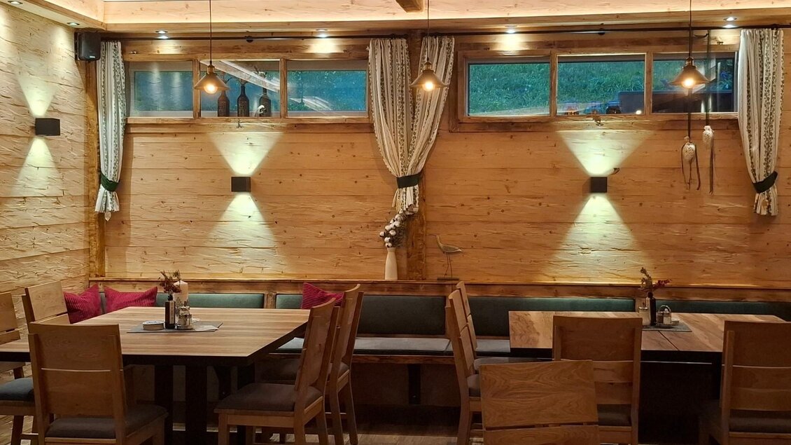 Gemütliche Tische im Wirtshaus Popp'n Angerl mit indirektem Licht an den Wänden. | © TVB Ausseerland Salzkammergut