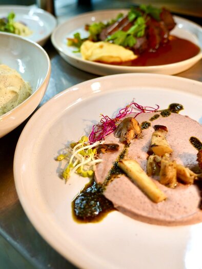 Verschiedene Teller mit Fleisch, Brotchips, Pilzcreme und Dessert im Restaurant Schanzlwirt Graz | © Wirtshaus Schanzlwirt