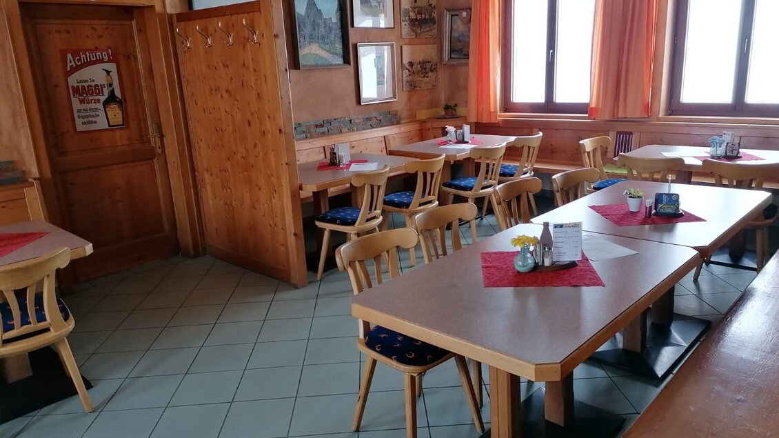 Ein gemütlicher Gastraum mit mehreren Tischen und Stühlen. Große Fenster lassen viel Licht herein und die Wände sind mit Bildern dekoriert. | © Wirtshaus "Zum Lebzelter"