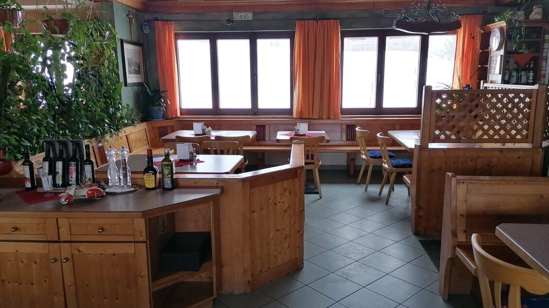 Ein gemütliches Restaurant mit Holzmöbeln und großen Fenstern. Einige Tische sind eingedeckt, und eine grüne Pflanze verschönert den Raum. | © Wirtshaus "Zum Lebzelter"