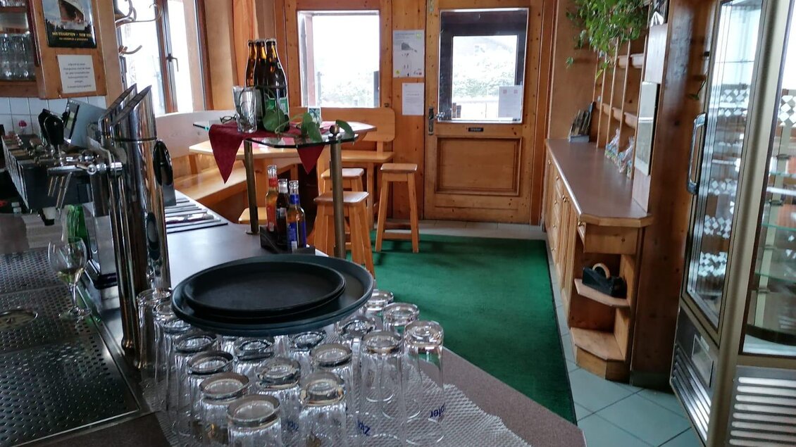 Der einladende Eingangsbereich des Wirtshaus zum Lebzelter mit Theke und Stühlen. Auf dem Tisch stehen Gläser und neben der Theke befindet sich ein Kühlschrank.</p></p> | © Wirtshaus "Zum Lebzelter"