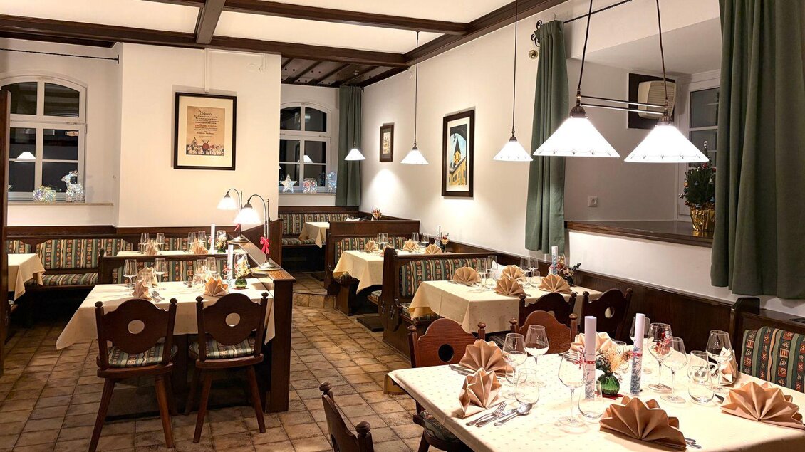 Ein gemütliches Restaurant mit Tischen, die liebevoll gedeckt sind. Die Atmosphäre ist warm und einladend, ideal für ein angenehmes Essen. | © Wirtshaus zum Römerstein