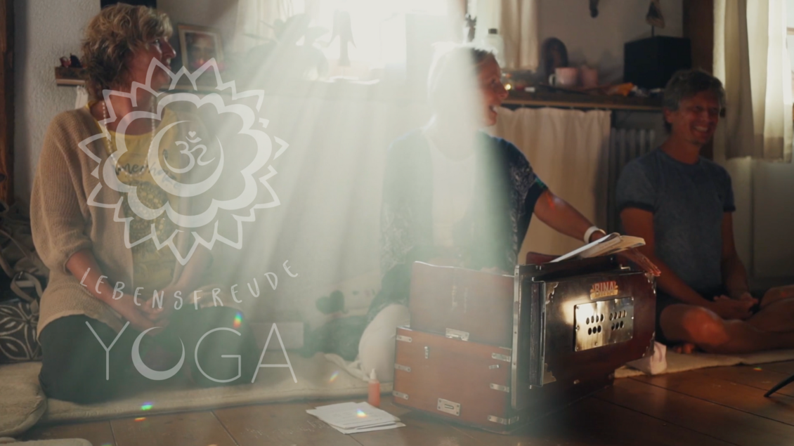 Eine gemütliche Yoga-Sitzung mit drei praktizierenden Menschen in einem hellen Raum. Lichtstrahlen fallen sanft auf die Teilnehmer und einen Harmonium. | © Tourismusverband Murau