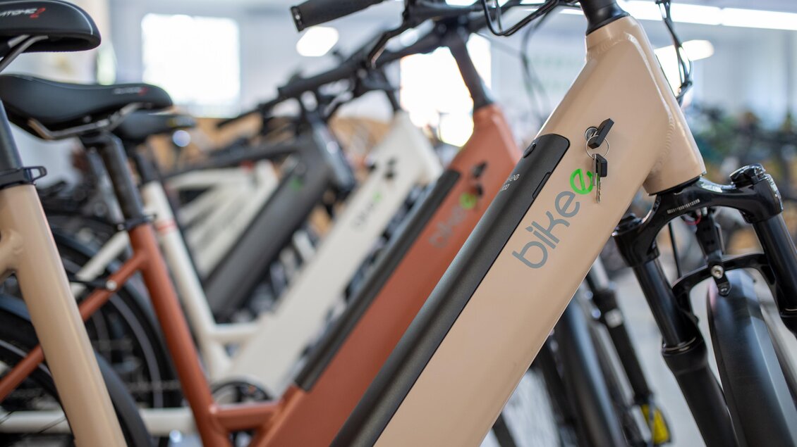 Eine Reihe von E-Bikes in verschiedenen Farben steht zur Ansicht. Die Räder haben ein modernes Design und sind in einem Innenraum ausgestellt. | © RM SWS GmbH | webquartier.at