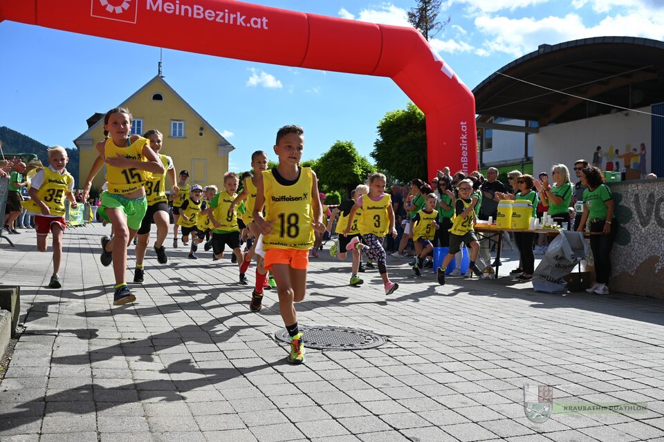 Eine Gruppe von Kindern läuft an einem Startbogen vorbei. Sie tragen leuchtende Trikots und die Stimmung ist lebhaft und fröhlich. | © Marktgmeinde Kraubath a.d.Mur