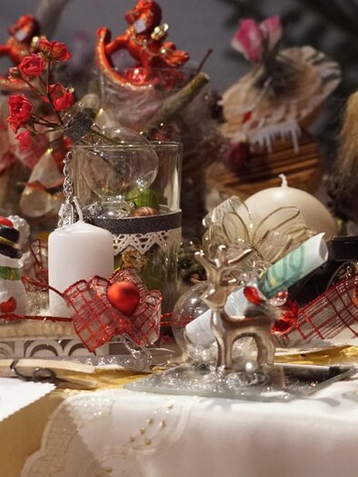 Ein festlich dekorierter Tisch mit verschiedenen Weihnachtsfiguren und Kerzen. Die Stimmung ist weihnachtlich und gemütlich. | © echtzeit-tv.