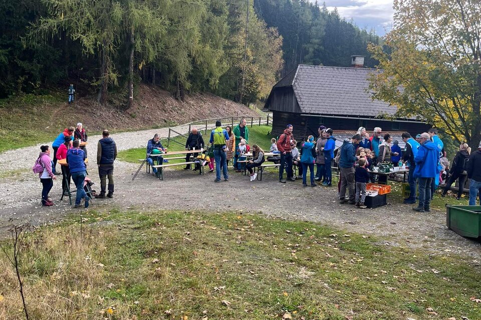 Eine Gruppe von Menschen versammelt sich im Freien, umgeben von Bäumen und einer Hütte. Es scheint eine gesellige Veranstaltung in der Natur zu sein. | © SV Union Mautern