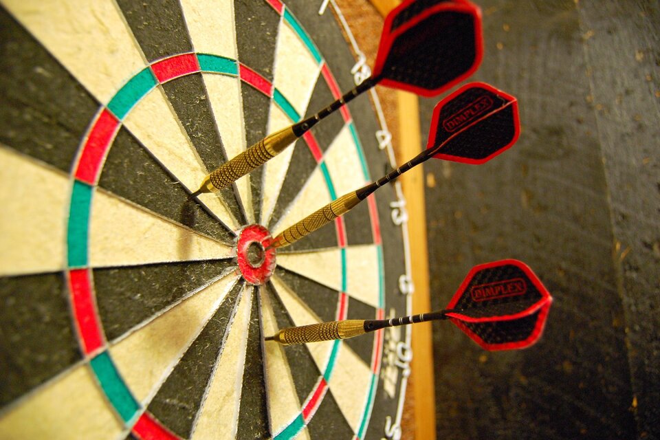 Eine Dartboard mit mehreren Pfeilen, die auf die Zielscheibe zeigen. Die Farben sind schwarz, rot und grün. | © pixabay.com