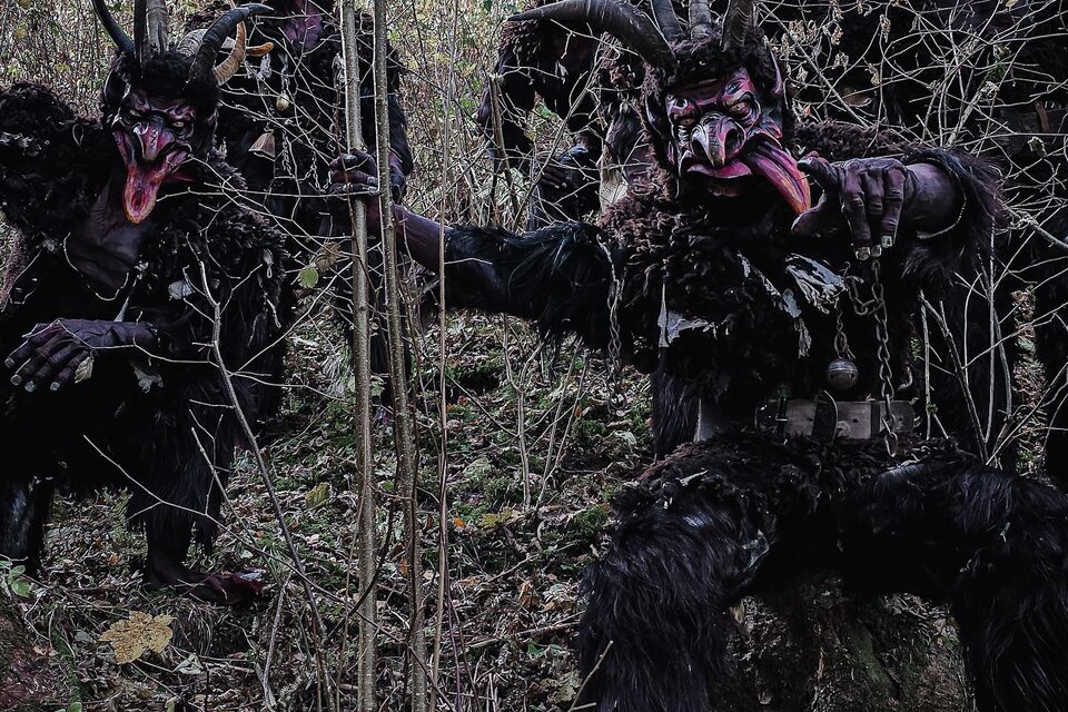 Eine Gruppe von verkleideten Figuren mit Hörnern steht im Wald. Sie scheinen Schatten und geheimnisvoll zu sein, umgeben von Bäumen und Pflanzen. | © Kraubather Ruasteifl