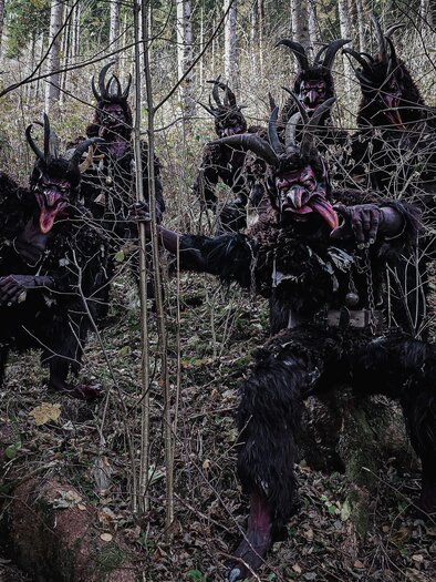 Eine Gruppe von verkleideten Figuren mit Hörnern steht im Wald. Sie scheinen Schatten und geheimnisvoll zu sein, umgeben von Bäumen und Pflanzen. | © Kraubather Ruasteifl