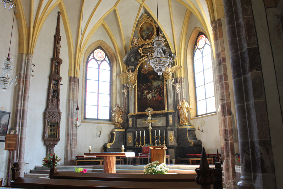 Die Stadtpfarrkirche von Bad Aussee mit einem eindrucksvollen Altar und mit hellen, hohen Kirchenfenstern mit bunden Glasscheiben mit Muster. Von der hohen Decke hängen Kronleuchter. Die Holzbänke laden zur Besinnung ein.</ | © Tourismusverband Bad Aussee