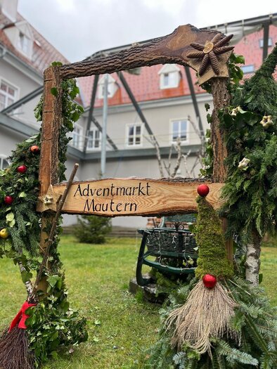 Eine weihnachtliche Christbaumkugel in Rot mit einer winterlichen Landschaft. Das Ornament zeigt ein kleines Haus und einen Baum auf einer schneebedeckten Fläche. | © Hirt Wolfgang