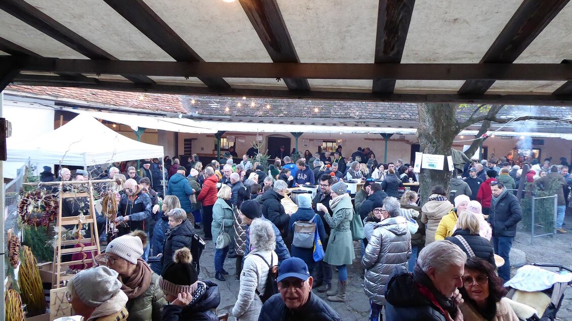 Beim überdachten Außenbereich herrscht reges Treiben bei den Verpflegungsständen beim Adventmarkt am Taggerhof in Kainbach bei Graz.  | © Manfred Schöninger