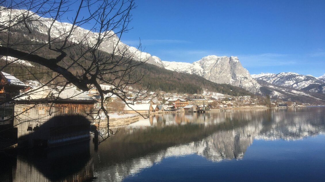 Ein malerischer See umgeben von schneebedeckten Bergen und einem klaren blauen Himmel. Die ruhige Wasseroberfläche spiegelt die Landschaft wider. | © Tourismusverband Ausseerland