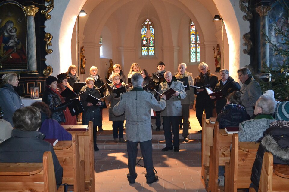 Ein Chor singt in einer Kirche. Die Zuschauer sitzen auf Holzbänken und lauschen der Musik. | © Karl Dobnigg