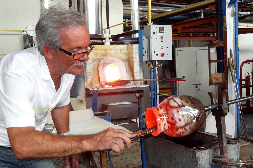 Glaskünstler Heinz Strasser formt an der Glasmacherpfeife ein glühendes, mundgeblasenes Glas in der Werkstatt. | © GlasMuseum Bärnbach